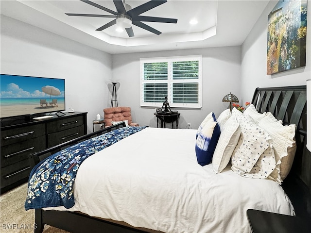 bedroom featuring carpet, ceiling fan, and a tray ceiling