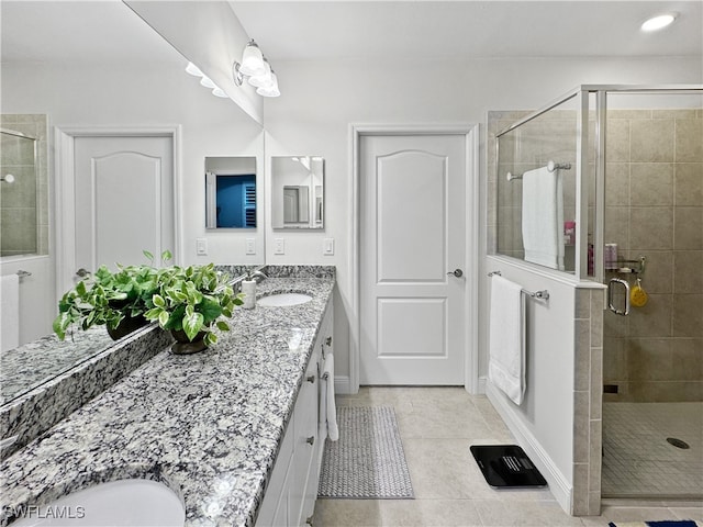 bathroom with vanity, a shower with shower door, and tile patterned floors