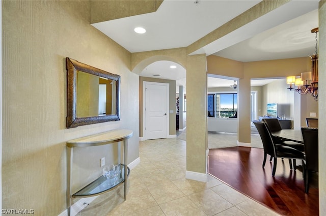 hallway with a chandelier and light hardwood / wood-style floors