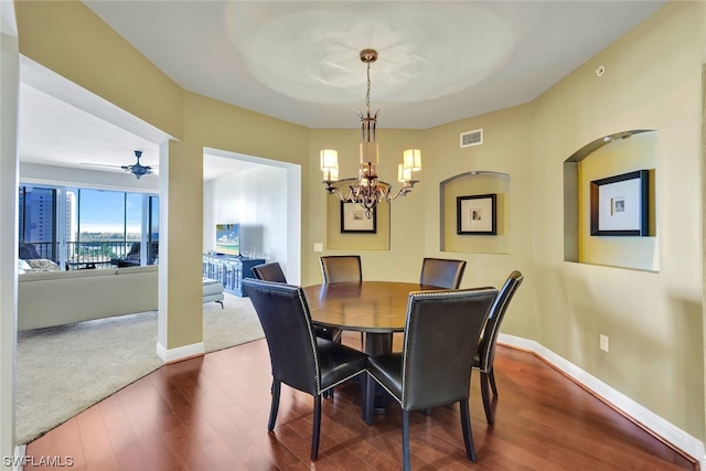 dining area featuring ceiling fan with notable chandelier and hardwood / wood-style flooring