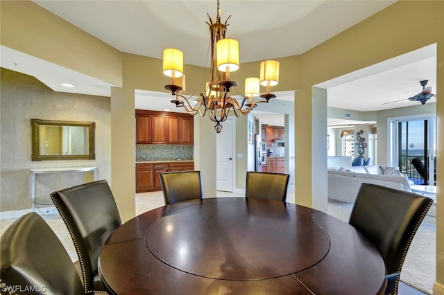 dining room featuring ceiling fan with notable chandelier