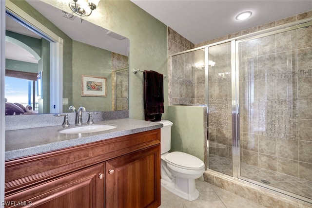 bathroom with tile patterned floors, vanity, toilet, and an enclosed shower