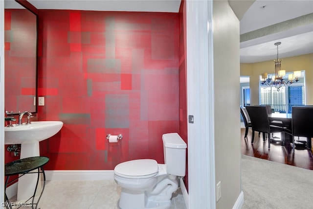 bathroom featuring tile patterned flooring, a chandelier, and toilet