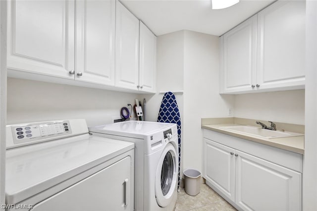 washroom featuring washer and clothes dryer, cabinets, light tile patterned floors, and sink