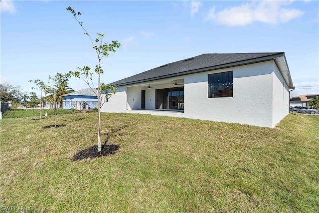 back of property with a yard and a patio area