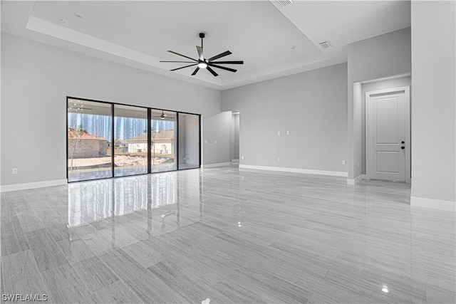 unfurnished room featuring a raised ceiling and ceiling fan