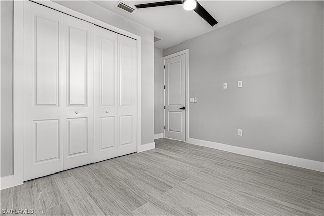 unfurnished bedroom featuring light wood-type flooring, ceiling fan, and a closet