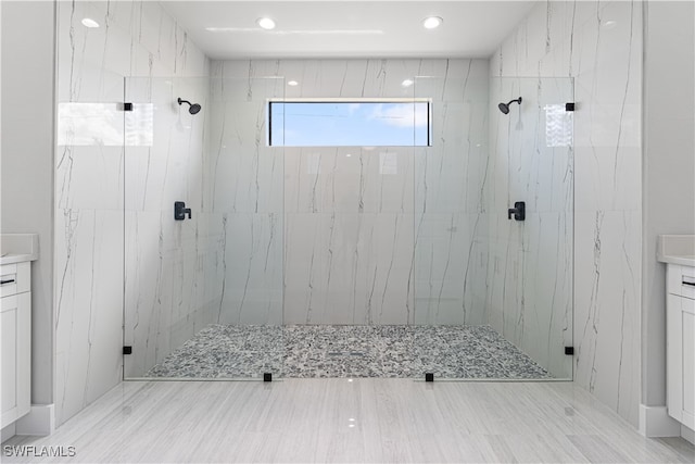 bathroom featuring walk in shower, vanity, and wood-type flooring