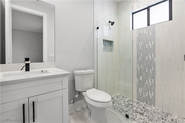 bathroom featuring vanity, toilet, and an enclosed shower