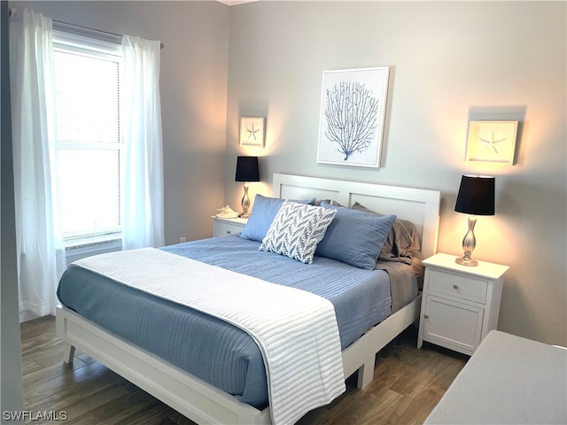 bedroom with dark hardwood / wood-style floors