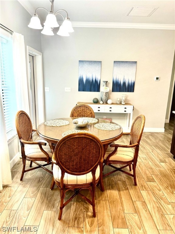 dining space with ornamental molding, light hardwood / wood-style floors, and an inviting chandelier