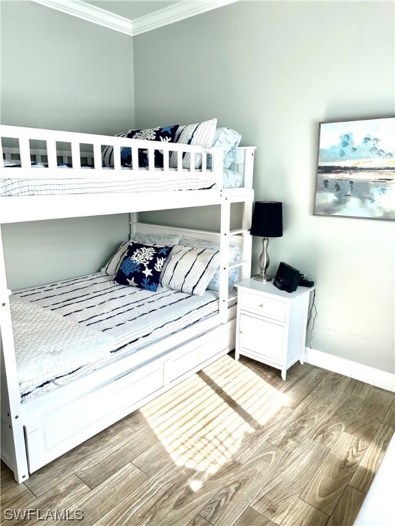 bedroom with light hardwood / wood-style floors and ornamental molding