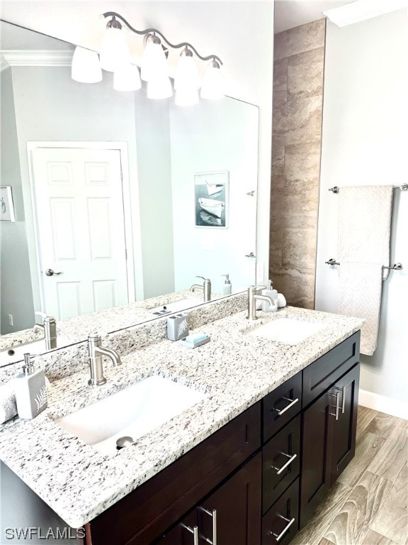 bathroom with hardwood / wood-style floors, ornamental molding, and dual vanity