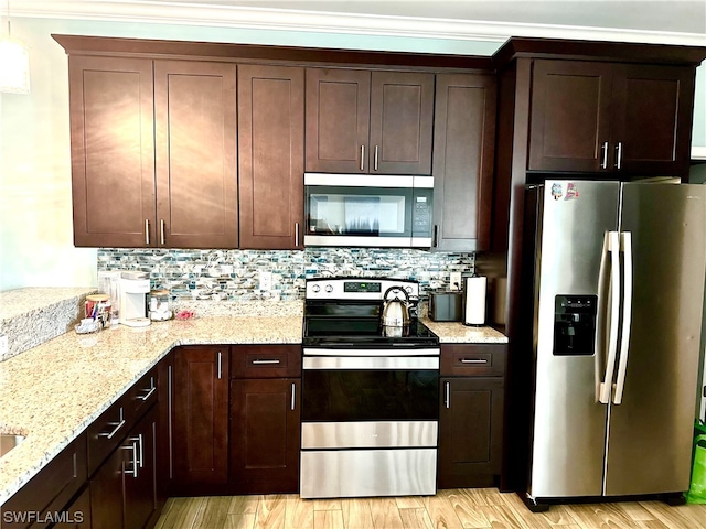 kitchen with light hardwood / wood-style floors, stainless steel appliances, light stone countertops, tasteful backsplash, and ornamental molding