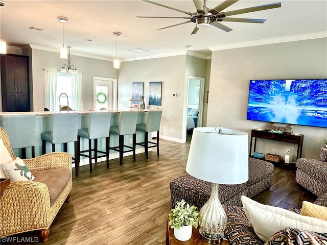 living room featuring ornamental molding, ceiling fan, and light wood-type flooring