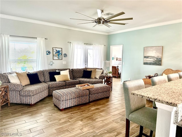 living room featuring ceiling fan, light wood-type flooring, and crown molding