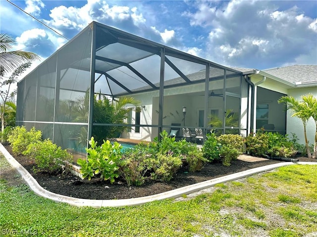 view of side of property with a lanai and ceiling fan