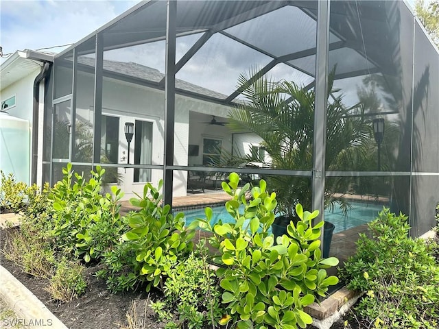 exterior space with ceiling fan and glass enclosure