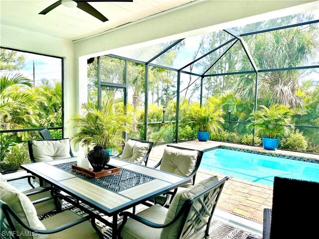 view of pool with ceiling fan, a patio, and glass enclosure