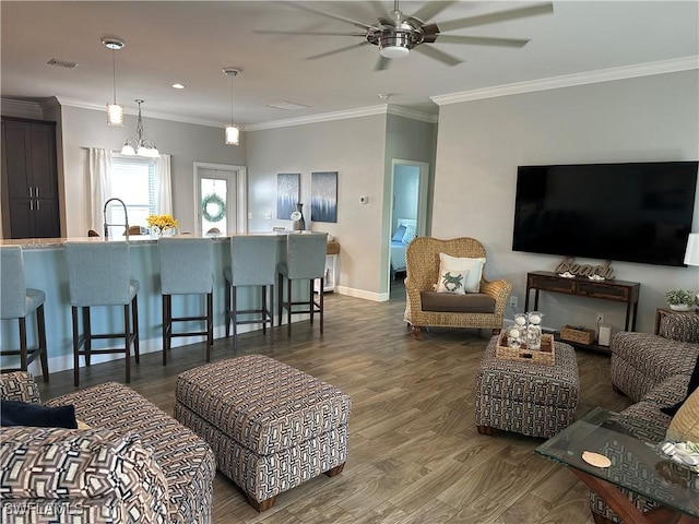 living room with dark hardwood / wood-style flooring, sink, crown molding, and ceiling fan