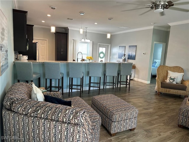 living room with crown molding, dark hardwood / wood-style floors, and ceiling fan