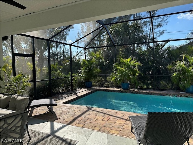 view of swimming pool featuring a patio and glass enclosure