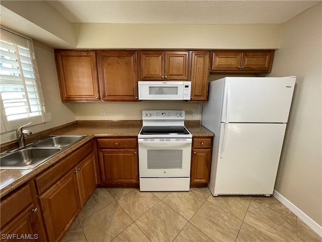 kitchen featuring sink, light tile patterned floors, a textured ceiling, and white appliances