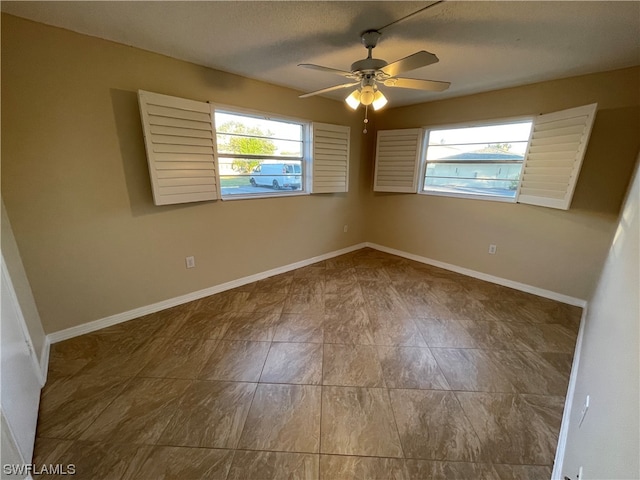 unfurnished room with a textured ceiling and ceiling fan