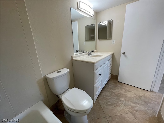 bathroom with vanity, a bathtub, and toilet