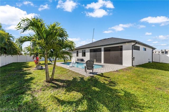 back of property with a lawn, a fenced in pool, and a patio