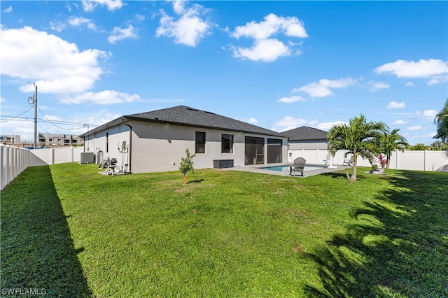 rear view of property with a lawn, a fenced in pool, and a patio