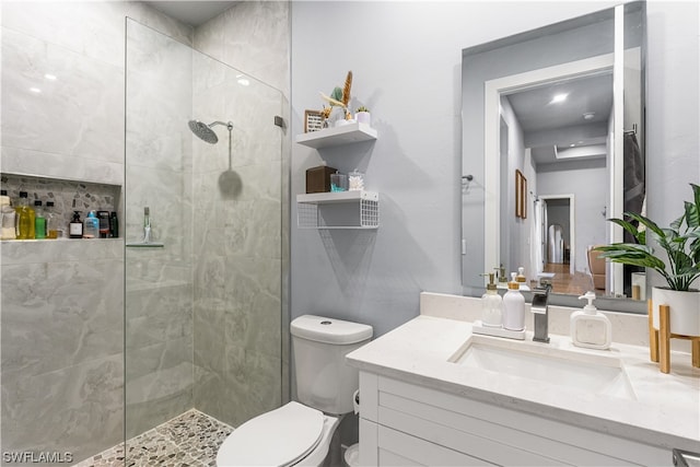 bathroom featuring toilet, vanity, and a shower with shower door