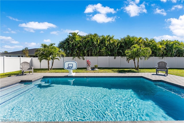 view of swimming pool with a patio and a yard