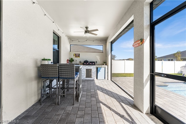 exterior space with a pool, an outdoor kitchen, and ceiling fan