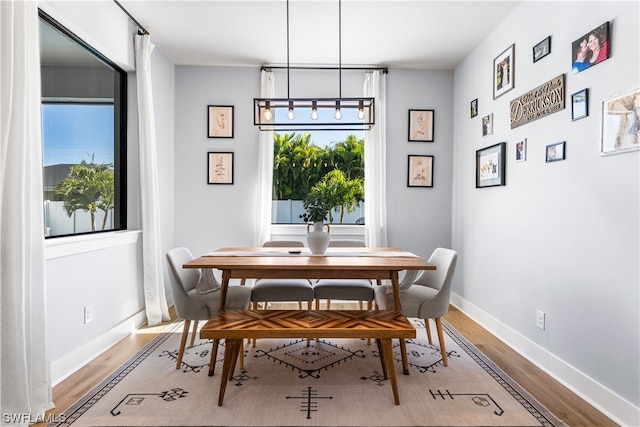 dining space with a chandelier and light hardwood / wood-style flooring