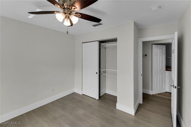 unfurnished bedroom featuring hardwood / wood-style floors, a closet, and ceiling fan