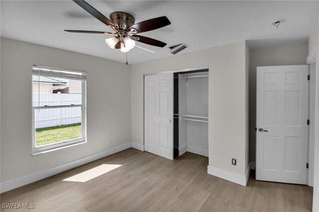 unfurnished bedroom featuring ceiling fan, light hardwood / wood-style floors, and a closet