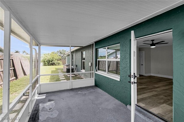 unfurnished sunroom with ceiling fan