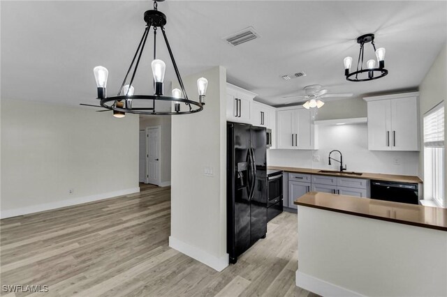 kitchen featuring black appliances, white cabinets, and butcher block countertops