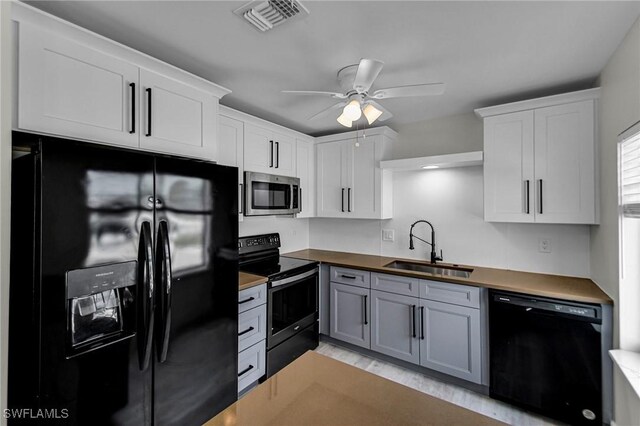 kitchen with black appliances, butcher block counters, white cabinetry, sink, and gray cabinets