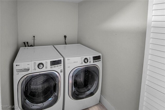 laundry area with light wood-type flooring and separate washer and dryer