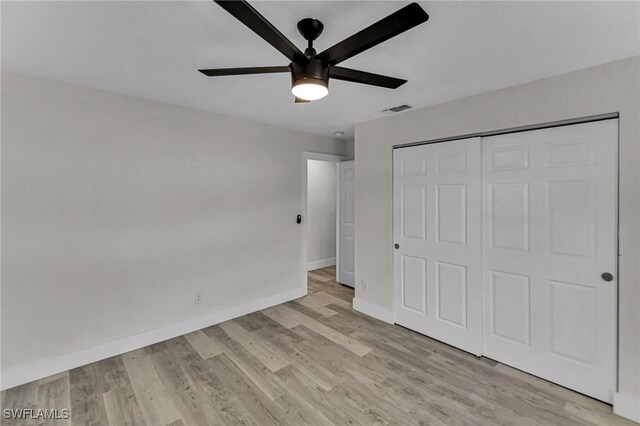 unfurnished bedroom with light wood-type flooring, a closet, and ceiling fan