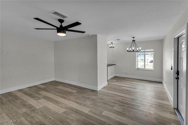 11315/17 Summerwinds Ct, Fort Myers, FL 33908 - unfurnished room with visible vents, ceiling fan with notable chandelier, baseboards, and wood finished floors