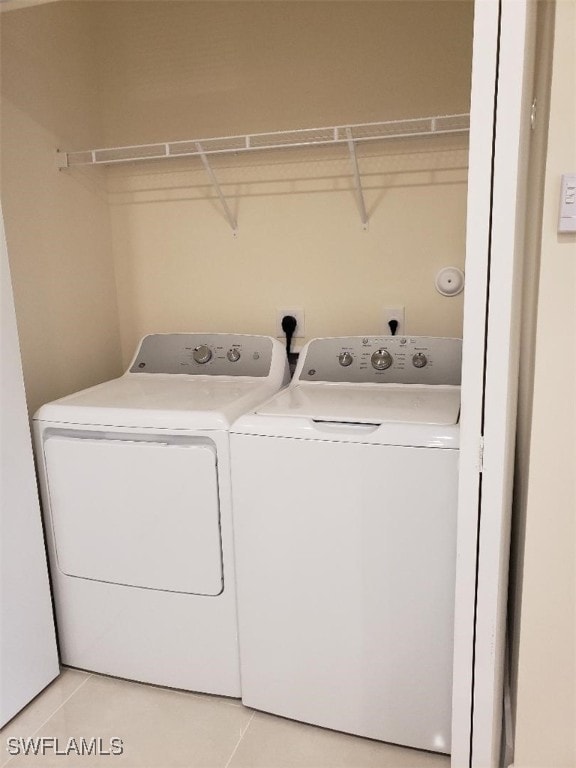 laundry area with washer and dryer and light tile patterned flooring