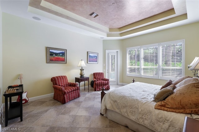 tiled bedroom with a tray ceiling