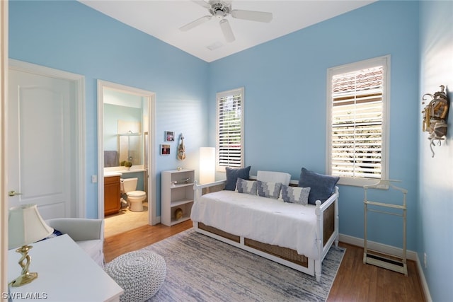 bedroom with ensuite bathroom, ceiling fan, and hardwood / wood-style flooring