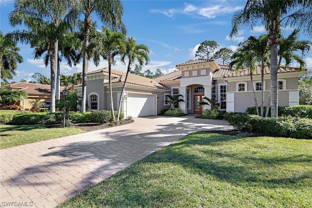 mediterranean / spanish house with a front lawn and a garage