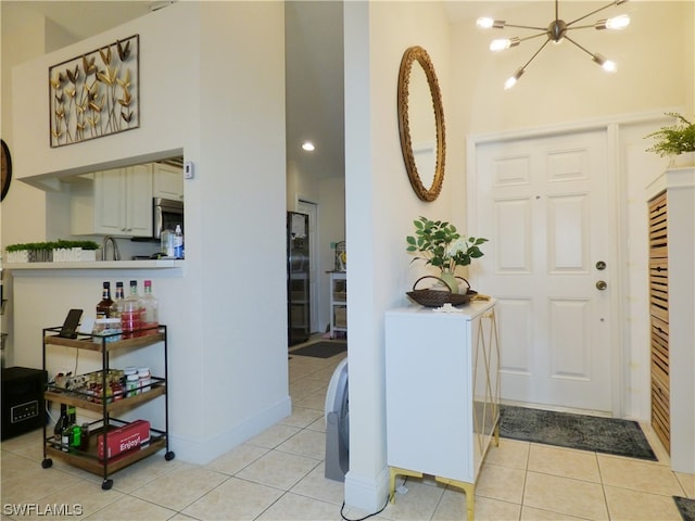 tiled entryway featuring an inviting chandelier