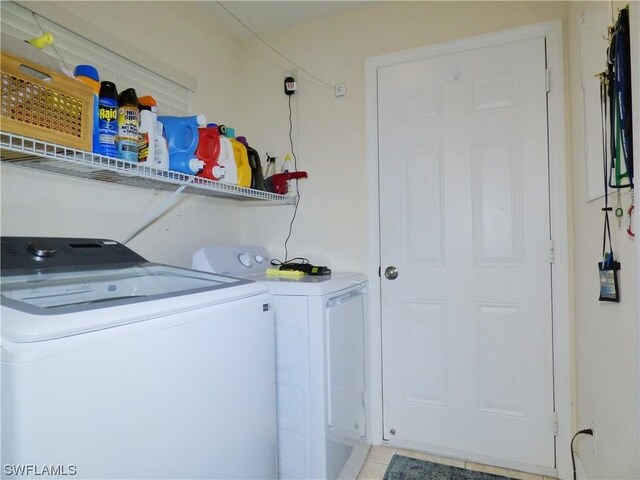 clothes washing area with light tile patterned floors and independent washer and dryer