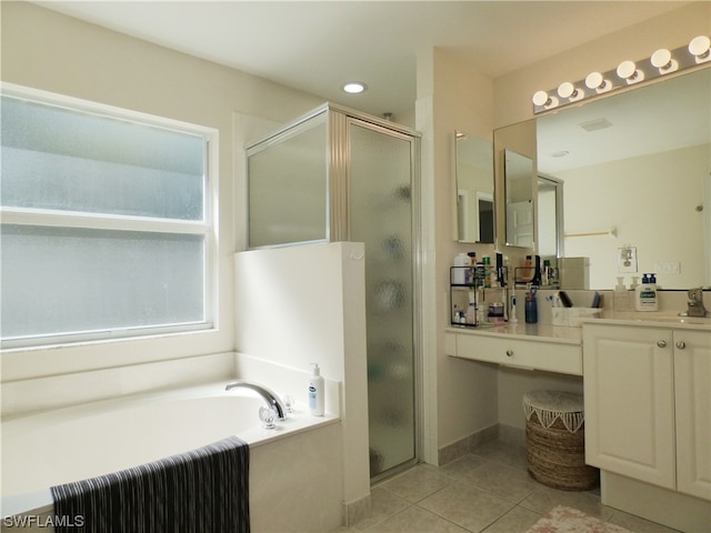 bathroom featuring plus walk in shower, vanity, and tile patterned floors